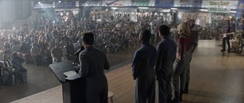 Movie still from “Galaxy Quest” (1999), directed by Dean Parisot – A group of people standing in front of an audience; Extreme Wide shot, High angle