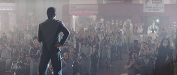 Movie still from “Galaxy Quest” (1999), directed by Dean Parisot – A crowd of people watching a man in a suit; Wide shot, Over the shoulder angle