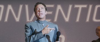 Movie still from “Galaxy Quest” (1999), directed by Dean Parisot – A man in a star trek uniform points to a microphone; Close Up shot, Low angle