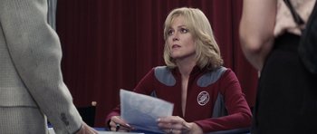 Movie still from “Galaxy Quest” (1999), directed by Dean Parisot – A woman sitting at a table holding a paper; Medium shot, Over the shoulder angle