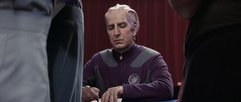 Movie still from “Galaxy Quest” (1999), directed by Dean Parisot – An older man with purple hair is writing on a piece of paper; Medium shot, Over the shoulder angle