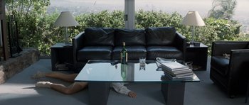 Movie still from “Galaxy Quest” (1999), directed by Dean Parisot – A man laying on the ground next to a coffee table; Wide shot, High angle