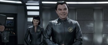Movie still from “Galaxy Quest” (1999), directed by Dean Parisot – A man and a woman dressed in black suits; Medium shot, Over the shoulder angle