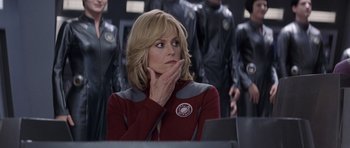Movie still from “Galaxy Quest” (1999), directed by Dean Parisot – A woman sitting in front of a group of people; Close Up shot, Over the shoulder angle