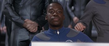Movie still from “Galaxy Quest” (1999), directed by Dean Parisot – A man in a blue and gray suit sitting in front of a computer screen; Close Up shot, Low angle