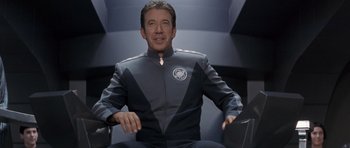 Movie still from “Galaxy Quest” (1999), directed by Dean Parisot – A man sitting in a chair wearing a uniform; Medium shot, Over the shoulder angle