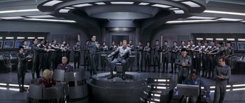Movie still from “Galaxy Quest” (1999), directed by Dean Parisot – A group of men in grey suits are sitting in a room; Wide shot, High angle