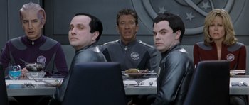Movie still from “Galaxy Quest” (1999), directed by Dean Parisot – A group of men sitting at a table with food; Medium shot, Over the shoulder angle