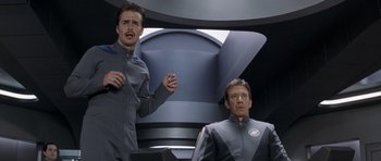 Movie still from “Galaxy Quest” (1999), directed by Dean Parisot – Two men are standing in front of each other; Medium shot, Low angle