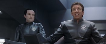 Movie still from “Galaxy Quest” (1999), directed by Dean Parisot – Two men sitting next to each other in a room; Medium shot, Over the shoulder angle