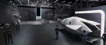 Movie still from “Galaxy Quest” (1999), directed by Dean Parisot – A man standing next to an airplane in a hangar; Extreme Wide shot, High angle