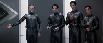 Movie still from “Galaxy Quest” (1999), directed by Dean Parisot – A group of men in black suits holding wii remotes in their hands; Medium shot, Low angle