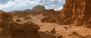 Movie still from “Galaxy Quest” (1999), directed by Dean Parisot – A view of a rocky desert area with a mountain in the background; Extreme Wide shot, High angle
