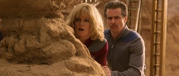 Movie still from “Galaxy Quest” (1999), directed by Dean Parisot – A man and a woman looking at a rock; Medium shot, Low angle