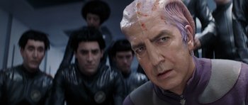 Movie still from “Galaxy Quest” (1999), directed by Dean Parisot – A group of people in a room with a man in a purple shirt; Close Up shot, Over the shoulder angle