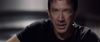 Movie still from “Galaxy Quest” (1999), directed by Dean Parisot – A person wearing a black t - shirt; Close Up shot, Over the shoulder angle