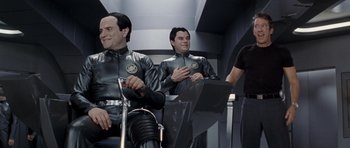 Movie still from “Galaxy Quest” (1999), directed by Dean Parisot – Two men in leather suits sitting next to each other; Medium shot, Over the shoulder angle