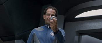 Movie still from “Galaxy Quest” (1999), directed by Dean Parisot – A man in a blue and gray suit holding a camera; Close Up shot, High angle