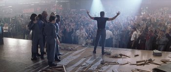 Movie still from “Galaxy Quest” (1999), directed by Dean Parisot – A crowd of people watching a man on a stage; Wide shot, Low angle