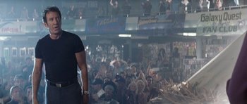 Movie still from “Galaxy Quest” (1999), directed by Dean Parisot – A crowd of people sitting and standing in front of a stage; Medium shot, Low angle