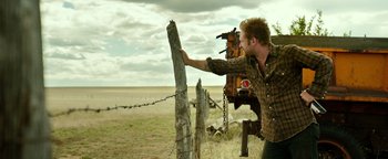 Movie still from “Hell or High Water” (2016), directed by David Mackenzie – A man holding onto a barbed wire fence; Medium shot, Low angle