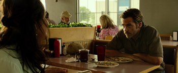 Movie still from “Hell or High Water” (2016), directed by David Mackenzie – A group of people sitting at a table with plates of food; Medium shot, Over the shoulder angle