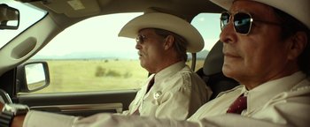 Movie still from “Hell or High Water” (2016), directed by David Mackenzie – A man wearing a cowboy hat sitting in the drivers seat of a car; Medium shot, Over the shoulder angle