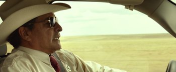 Movie still from “Hell or High Water” (2016), directed by David Mackenzie – An older man driving a car in the desert; Close Up shot, Over the shoulder angle