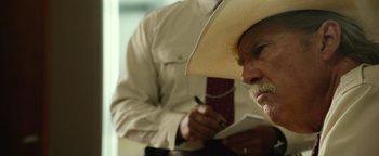 Movie still from “Hell or High Water” (2016), directed by David Mackenzie – A man in a cowboy hat writing on a piece of paper; Close Up shot, Over the shoulder angle