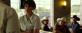 Movie still from “Hell or High Water” (2016), directed by David Mackenzie – A woman sitting in front of a man wearing a cowboy hat; Close Up shot, Over the shoulder angle