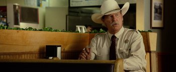 Movie still from “Hell or High Water” (2016), directed by David Mackenzie – A man in a cowboy hat sitting at a table in a restaurant; Medium shot, Over the shoulder angle