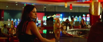Movie still from “Hell or High Water” (2016), directed by David Mackenzie – A woman sitting at a bar with other people sitting around; Medium shot, Over the shoulder angle