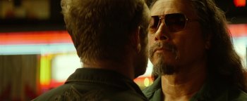 Movie still from “Hell or High Water” (2016), directed by David Mackenzie – A man with a goatee and sunglasses is talking to another man; Close Up shot, Over the shoulder angle