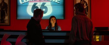 Movie still from “Hell or High Water” (2016), directed by David Mackenzie – A woman sitting in front of two other people; Medium shot, Over the shoulder angle