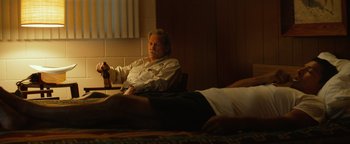 Movie still from “Hell or High Water” (2016), directed by David Mackenzie – A man sitting on a bed next to another man; Medium shot, Low angle