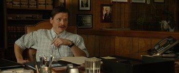Movie still from “Hell or High Water” (2016), directed by David Mackenzie – A man sitting at a table in front of papers; Medium shot, Over the shoulder angle