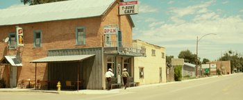 Movie still from “Hell or High Water” (2016), directed by David Mackenzie – Two men are standing on the side of the street; Extreme Wide shot, Over the shoulder angle