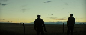 Movie still from “Hell or High Water” (2016), directed by David Mackenzie – A man standing in the middle of an open field at dusk; Wide shot, Low angle