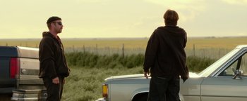 Movie still from “Hell or High Water” (2016), directed by David Mackenzie – A man standing next to a truck in a field; Medium shot, Over the shoulder angle
