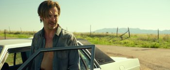 Movie still from “Hell or High Water” (2016), directed by David Mackenzie – A man standing next to a car in a field; Medium shot, Low angle