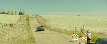 Movie still from “Hell or High Water” (2016), directed by David Mackenzie – A car driving down a dirt road next to a fence; Extreme Wide shot, High angle