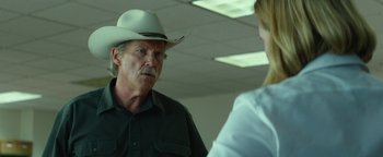 Movie still from “Hell or High Water” (2016), directed by David Mackenzie – An older man wearing a cowboy hat talking to a woman; Close Up shot, Over the shoulder angle