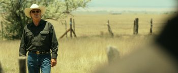 Movie still from “Hell or High Water” (2016), directed by David Mackenzie – A man standing in the middle of an open field; Medium shot, Over the shoulder angle