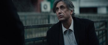 Movie still from “Hellraiser” (2022), directed by David Bruckner – A man sitting on top of a wooden bench; Close Up shot, Low angle