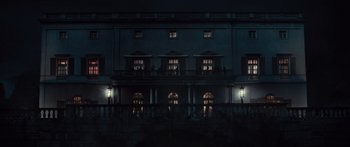 Movie still from “Hellraiser” (2022), directed by David Bruckner – A building that has been lit up at night; Extreme Wide shot, Low angle