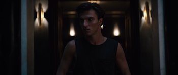 Movie still from “Hellraiser” (2022), directed by David Bruckner – A young man standing in a dimly - lit room; Close Up shot, Low angle