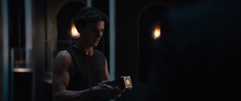 Movie still from “Hellraiser” (2022), directed by David Bruckner – A man holding a box in a dark room; Close Up shot, Over the shoulder angle