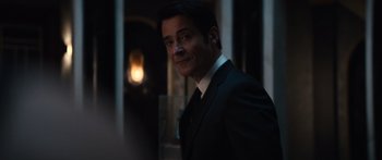 Movie still from “Hellraiser” (2022), directed by David Bruckner – A man wearing a suit and tie standing in a room; Close Up shot, Over the shoulder angle