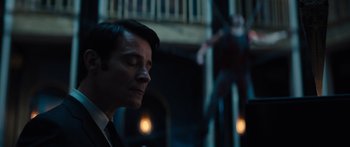 Movie still from “Hellraiser” (2022), directed by David Bruckner – A man in a suit and tie in a dark room; Medium shot, Low angle