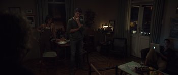 Movie still from “Hellraiser” (2022), directed by David Bruckner – A man standing in a living room next to a woman; Wide shot, High angle